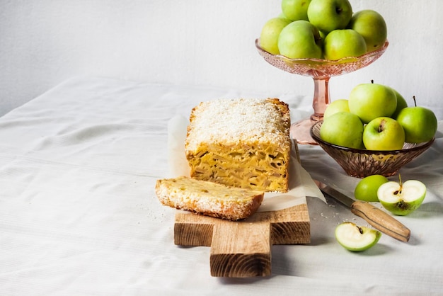 Apple and coconut loaf cake and apples in a vase on a table