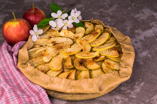 Apple crumble on a gray background decorated with apple flowers