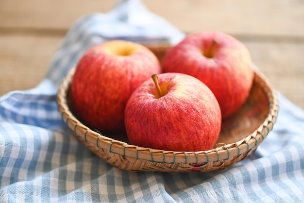 Apple fruit on basket on the wooden table ripe red apples