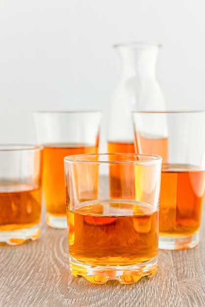 Apple juice in glasses and a bottle on a wooden surface