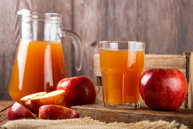 Apple juice and red apples on the table.