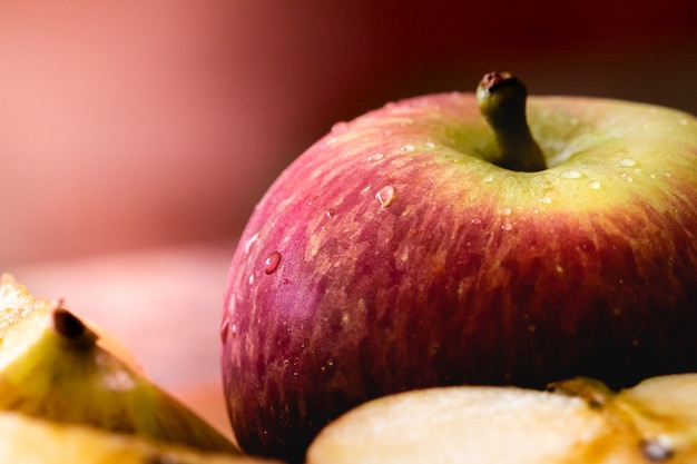 an apple in macro photography with a few drops of water with apple pieces in the composition