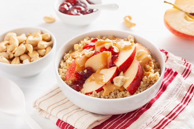 Apple peanut butter quinoa bowl with jam and cashew for healthy breakfast