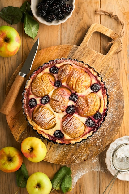 Apple pie Apple and blackberries cake or pie decorated sugar powder on old wooden table Delicious dessert for autumn or winter dinner Autumn pastry dessert Top view