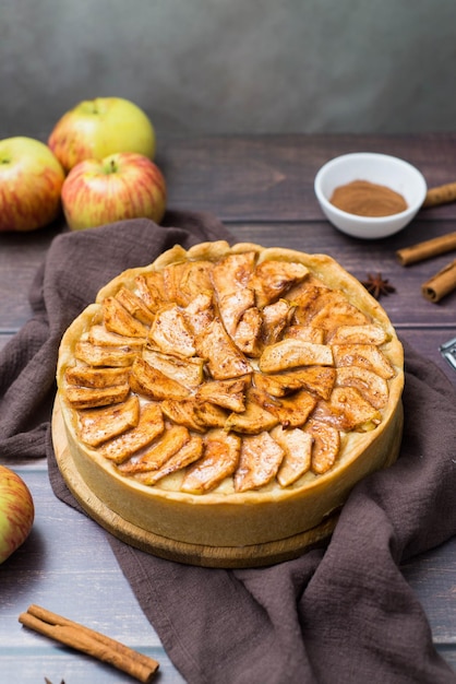 Apple pie with cinnamon on wooden and brown napkin