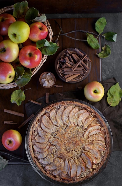 Apple pie with fresh fruits on a wooden table