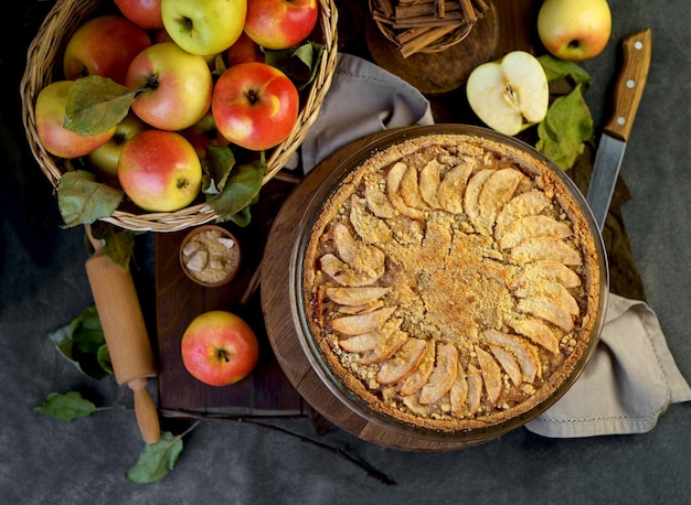 Apple pie with fresh fruits on a wooden table