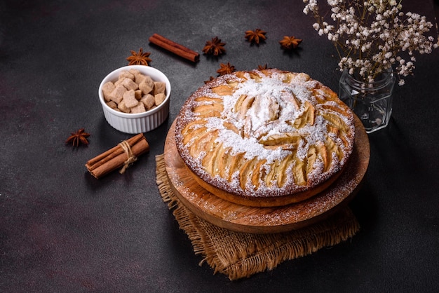 Apple pie with fresh fruits on a wooden table