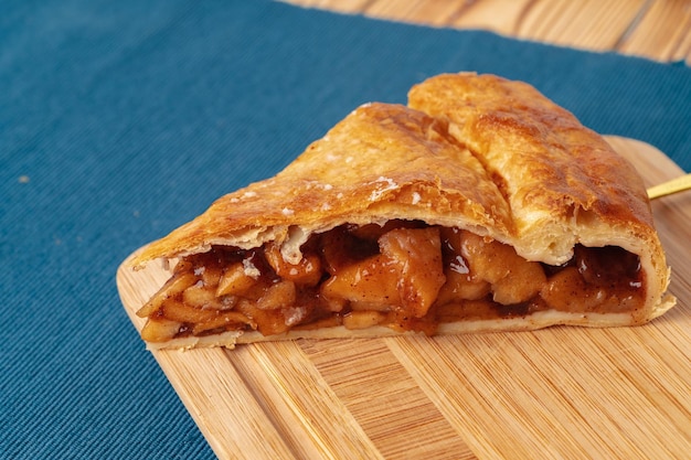 Apple pie on a wooden board cut into pieces