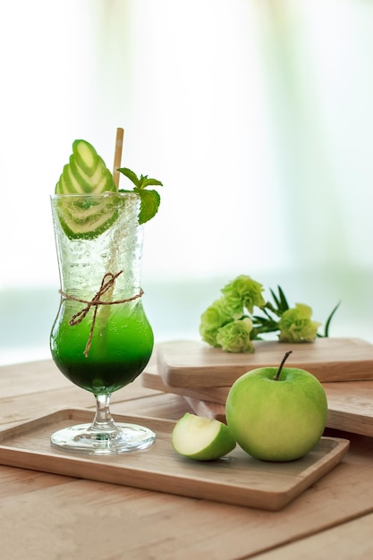 Apple soda with ice in glass on the table wooden