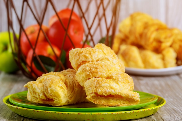 Apple strudel with fresh red and green apples in basket on table