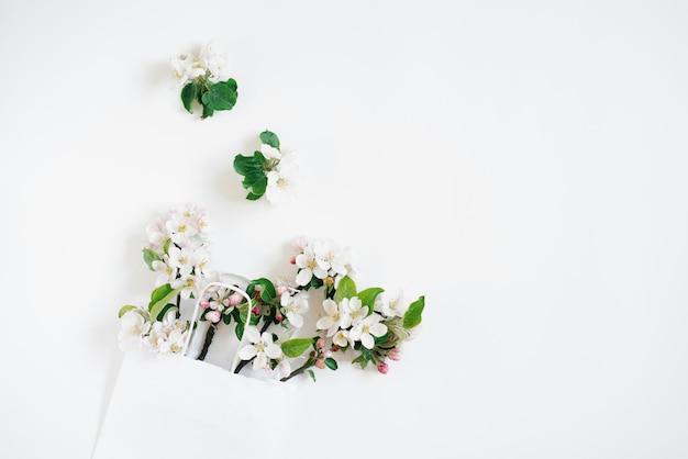 Apple tree flowers in a shopping bag on a white background with copy space