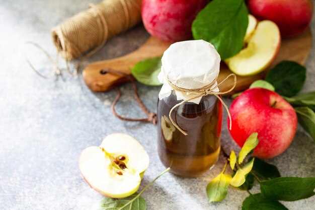 Apple vinegar Healthy organic food A bottle of apple cider vinegar on a light stone countertop