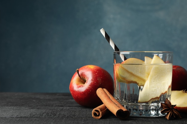 Apple, water and cinnamon on wooden, close up