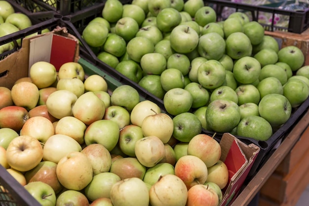 Apples of different varieties in boxes in the store Vitamins and healthy food New harvest