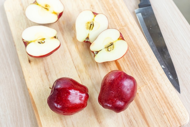 Apples and slices on wooden cutting board..