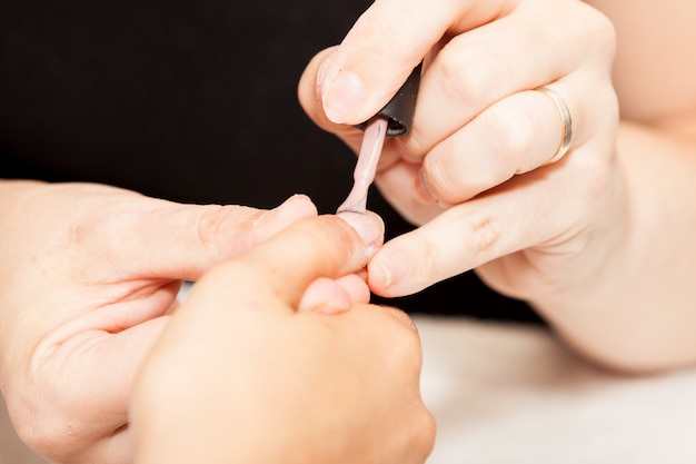 Applying nail polish on a woman's hands