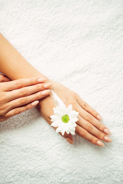 Applying natural cream on a hand on a white background