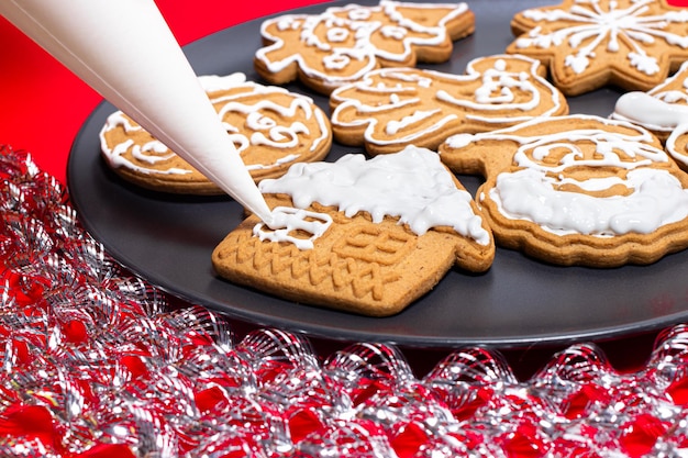 Applying white cream to Christmas cookies