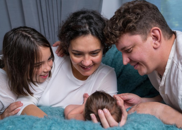 appy family with a newborn baby Mom and dad looking tenderly at the baby