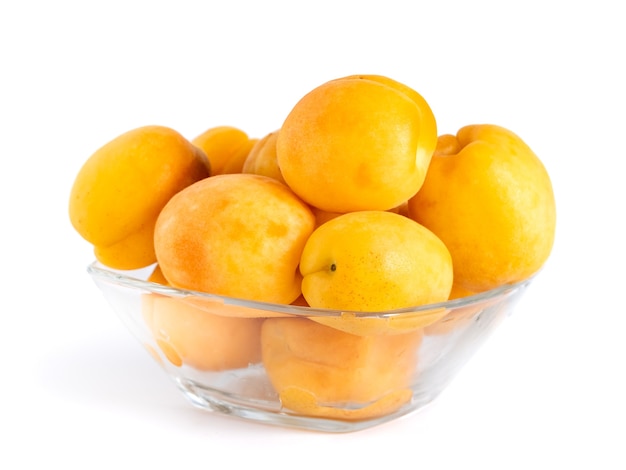 Apricot fruits in the glass bowl isolated on white, healthy food