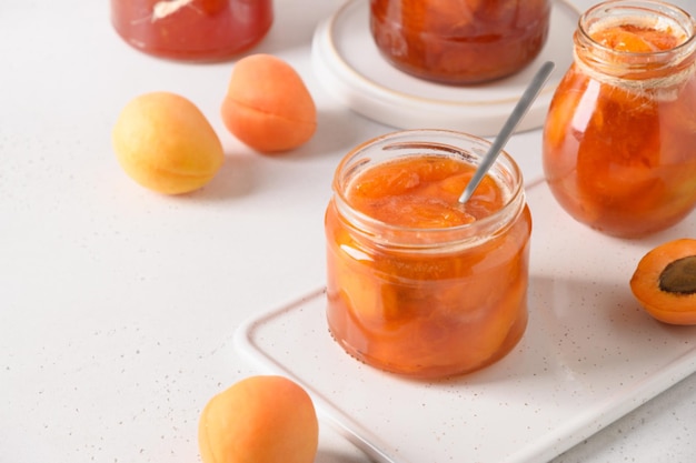 Apricot jam in glass jar with fruits summer harvest and canned food