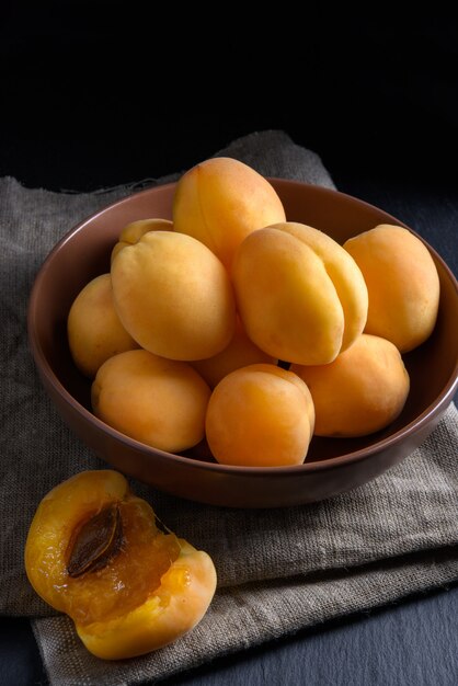 Apricots in a bowl on dark background