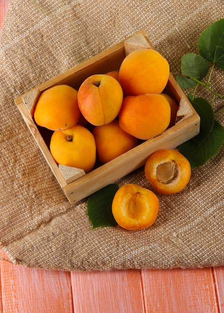 Apricots in drawer on bagging on wooden table