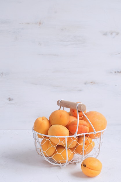 Apricots and peaches in metal basket Summer fruit  Harvesting Organic fruits White 