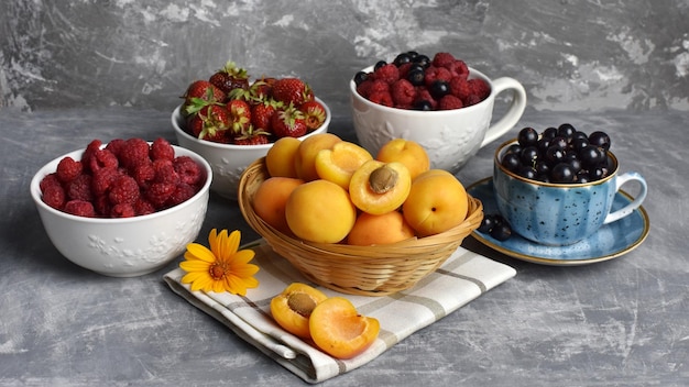 Apricots in a wicker basket currants raspberries strawberries still life Summer berries and fruits