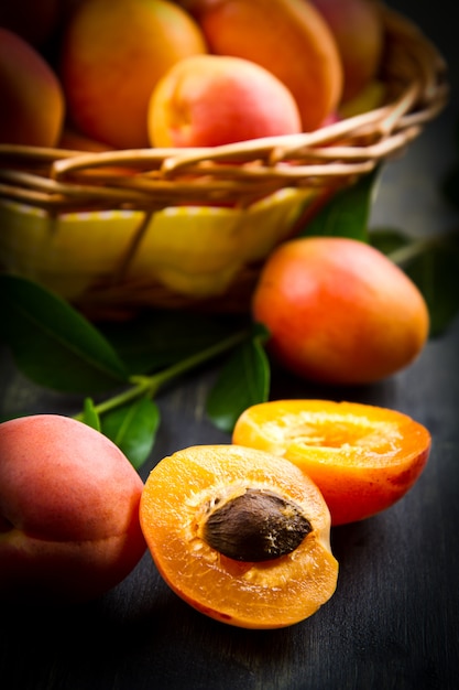 Apricots with leaves on the old wooden table