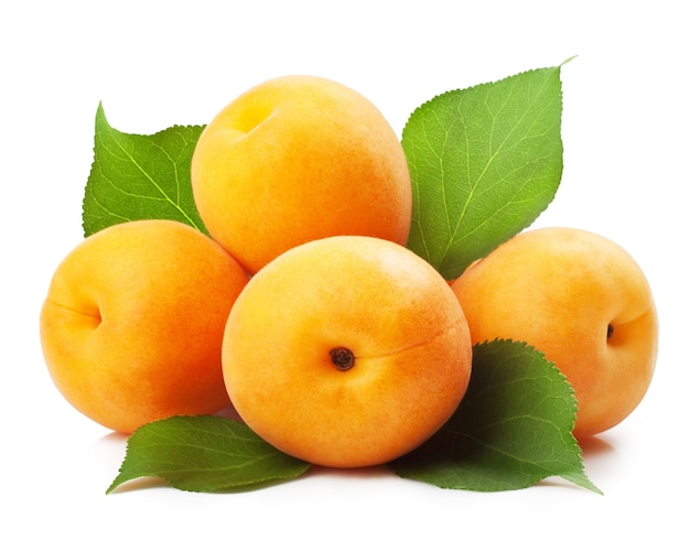 Apricots with leaves on a white surface