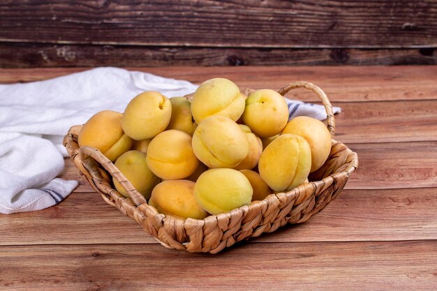 Apricots on wood background A pile of fresh apricots in a basket close up