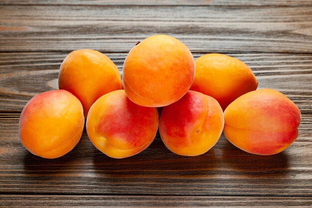 Apricots on wooden background Fresh juicy apricots piled on a wooden table