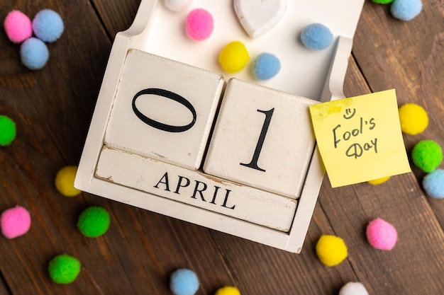 Photo april 1st image of april 1 wooden calendar with colorful decor on wooden background april fool's day