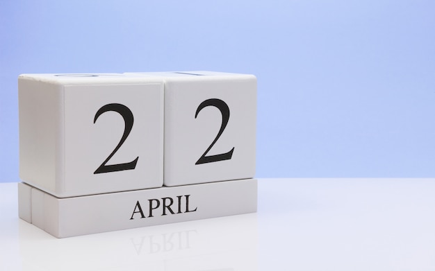 Photo april 22st. day 22 of month, daily calendar on white table with reflection