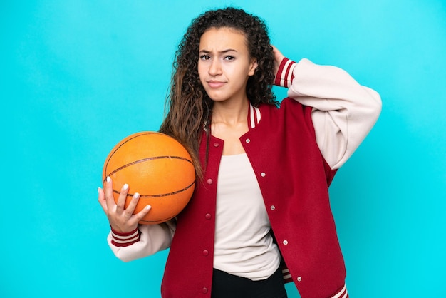 Arab basketball player woman isolated on blue background having doubts