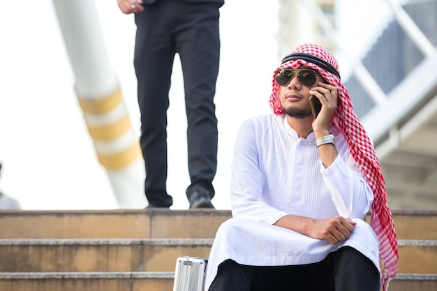 Arab business men sitting call phone working in the city