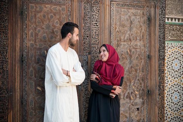 Photo arab couple in relationship talking and smiling in traditional clothing