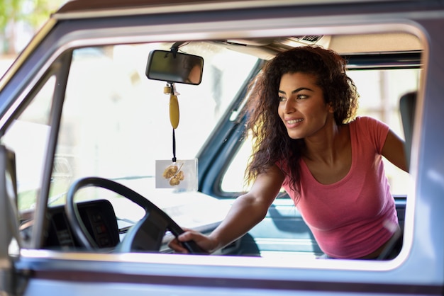 Arab girl inside an old van parked in a campsite in the middle of nature