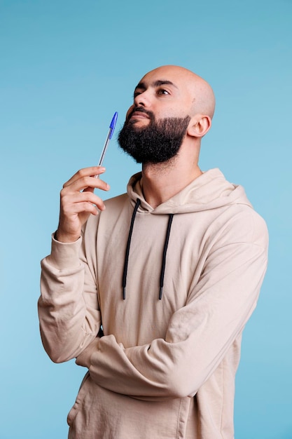 Arab man holding pen in contemplation