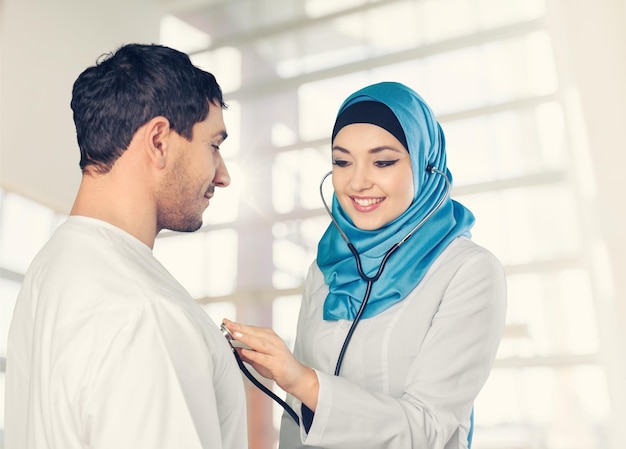 Arab saudi doctor woman examining patient isolated on a white background