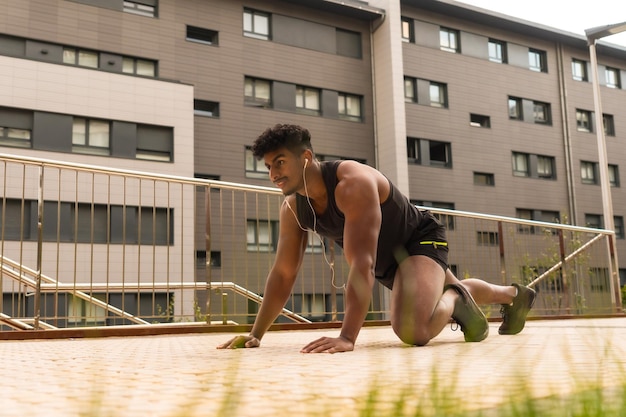 Arab strong young man doing sports in the city doing some pushups in a public park