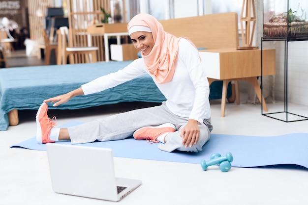 Arab woman doing gymnastics in the bedroom.