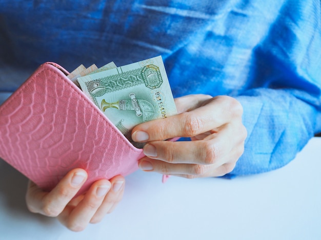 An Arab woman holds UAE dirhams.