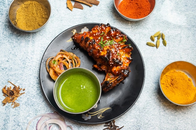 Arabian BBQ Tandoori chicken with chili sauce served in a dish isolated on grey background top view of bangladesh food