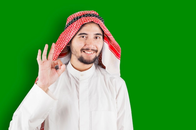 Arabian businessman showing OK sign on studio