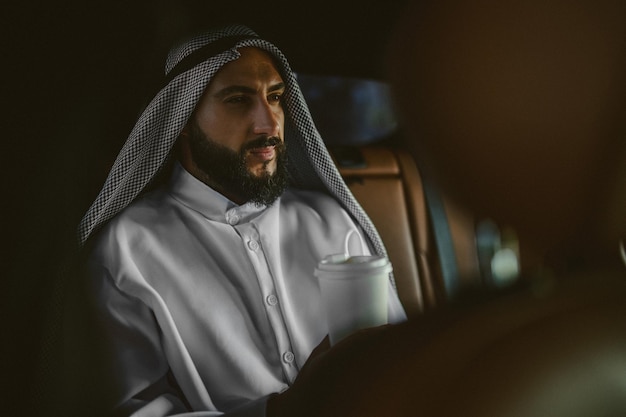 Arabian man A man in a traditional arabian clothing in a car