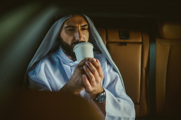 Arabian man A man in a traditional arabian clothing in a car