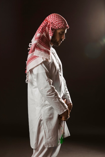 Arabian man with kandora standing and praying